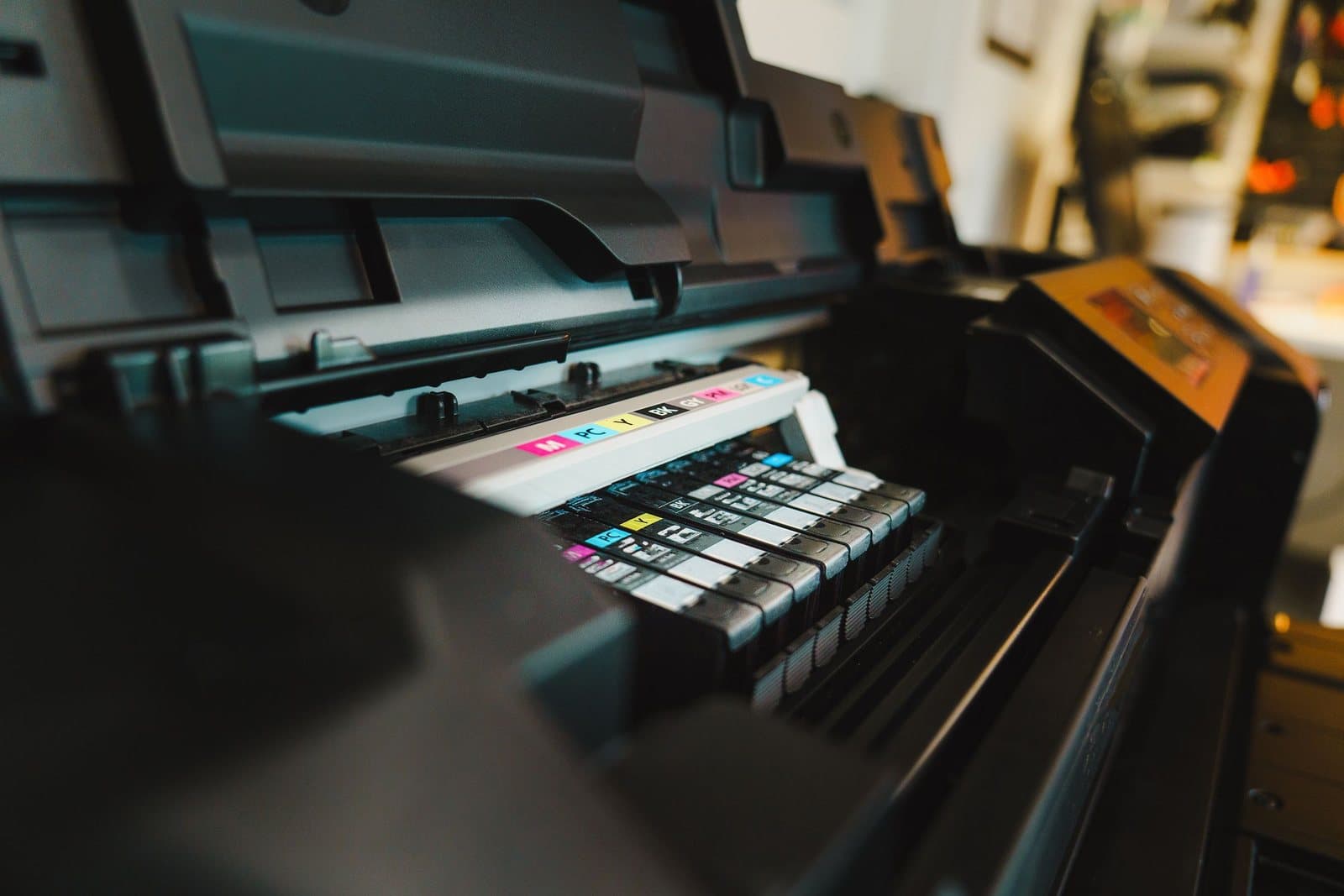 Close-up of the ink cartridge bay of a wide-format inkjet printer in a print studio.