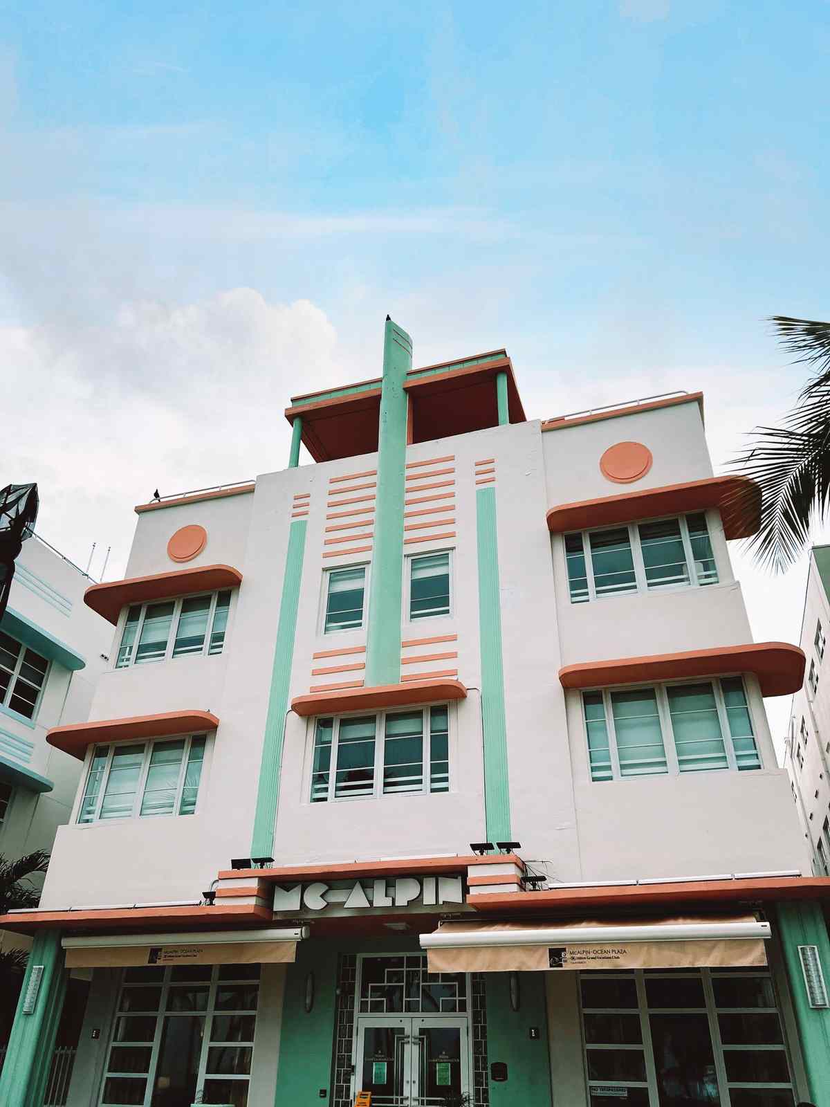 Pastel art deco hotel facade in Miami with stepped geometric lines and circular details