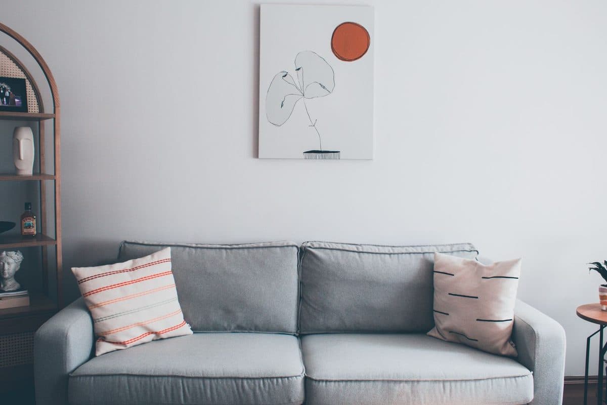 Single line-art canvas hanging above a grey sofa in a living room