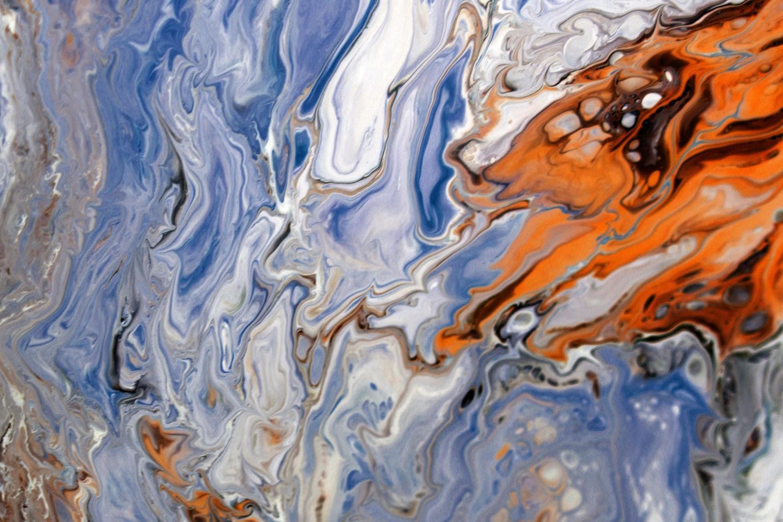 A close-up photograph of fluid art swirling in blue, white and burnt orange — the kind of saturated, glossy image typically showcased on metal prints.